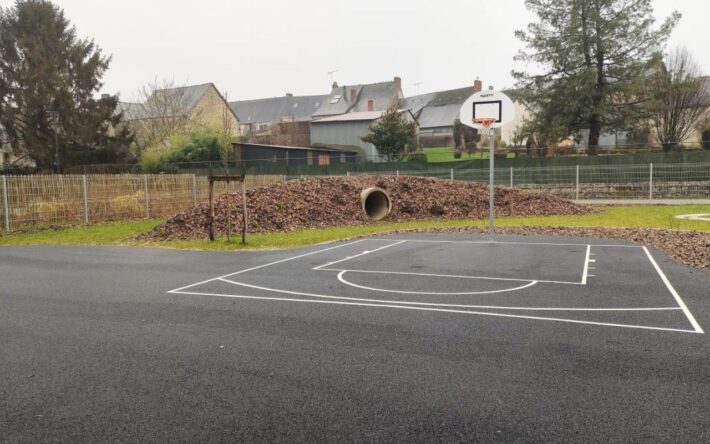 En herbe, en copeaux, en enrobé poreux, toutes les surfaces sont accessibles aux enfants à la récré. Le revêtement perméable du terrain de basket a un aspect similaire à un enrobé classique - Crédits photo : Banque des Territoires